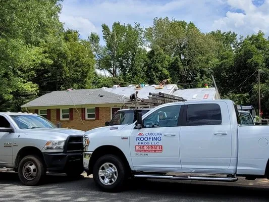 Carolina Roofing Pros work trucks at a roofing project