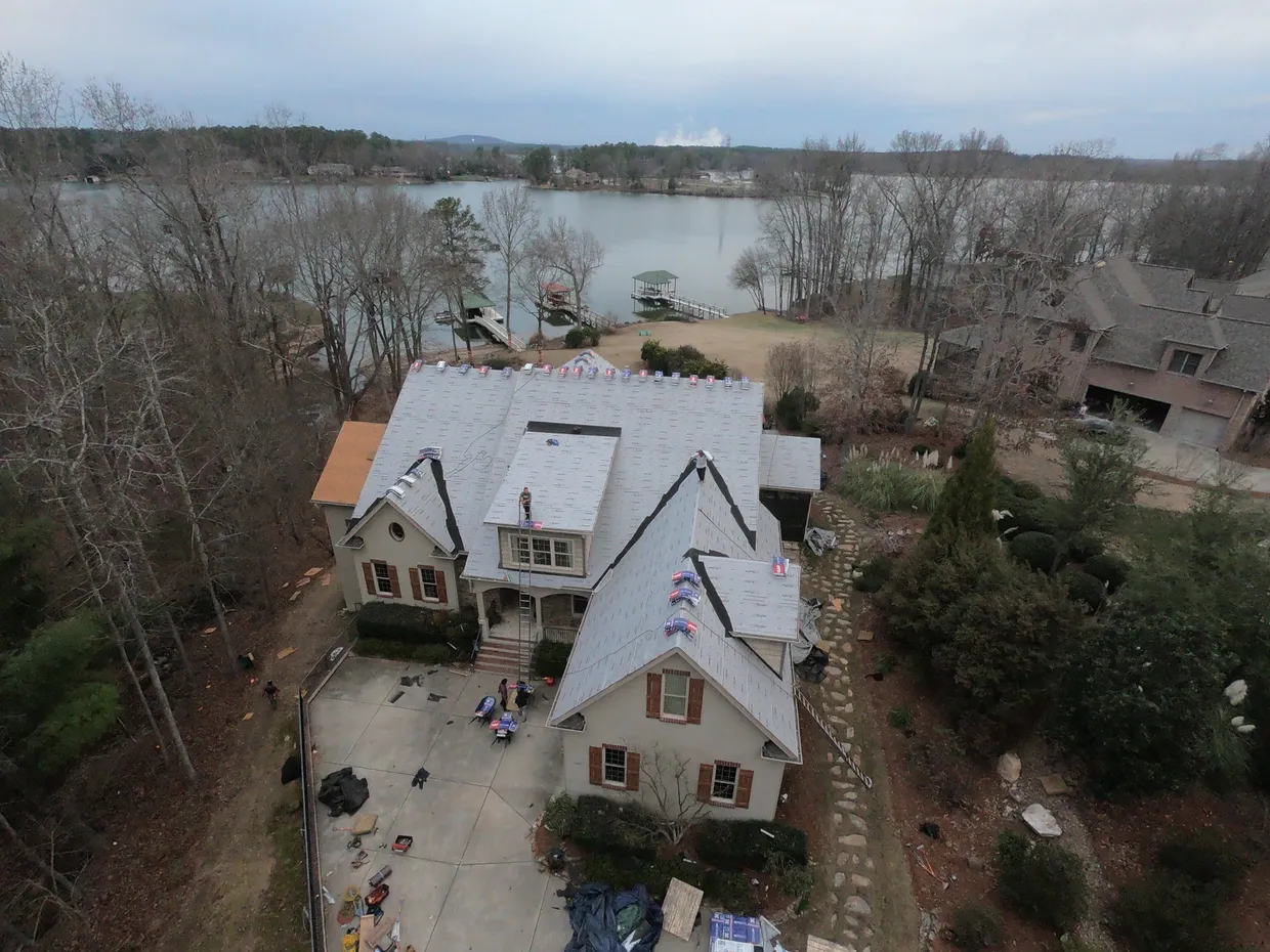 Roof replacement in progress on a lakefront home